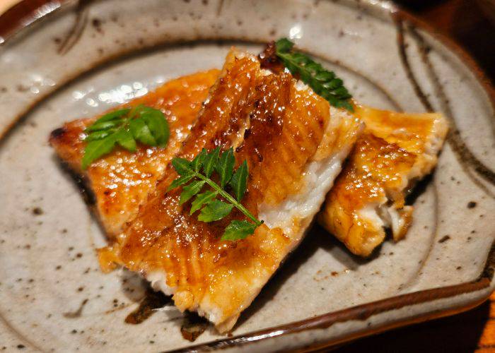 Kansai-style kabayaki unagi, gently brushed with sauce and garnished with herbs.